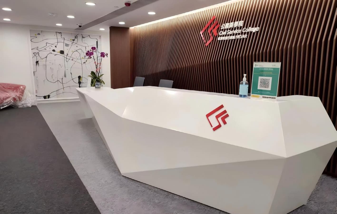 Minimalist geometric white solid surface reception counter in corporate office lobby